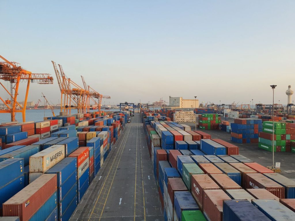 A bustling port scene with colorful cargo containers at sunrise. Ideal for logistics concepts.